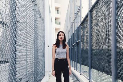 Portrait of young woman standing on wall