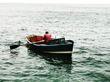 Rear view of man in boat at sea