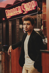 Portrait of young man standing at home