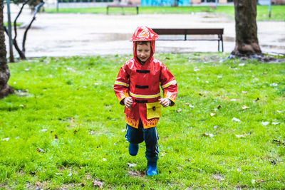 Full length of boy running on grass at park