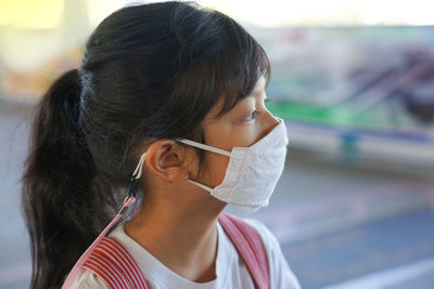 New normal lifestyle of asian cute girl using the fabric mask standing and waiting sky train