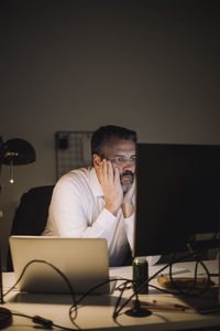 Ambitious businessman working on computer last minute at work place