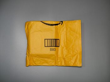 Close-up of yellow mailbox against white background