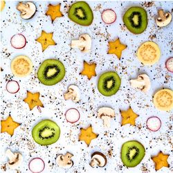 Directly above view of fresh fruits and mushrooms slices on table