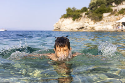 Portrait of boy swimming in sea