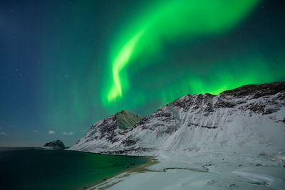 Scenic view of snowcapped mountains against sky at night