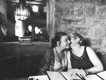 Mother kissing daughter in restaurant