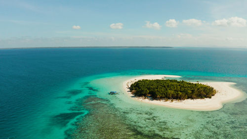 Tropical island with sandy beach by atoll with coral reef and blue sea. patawan island 