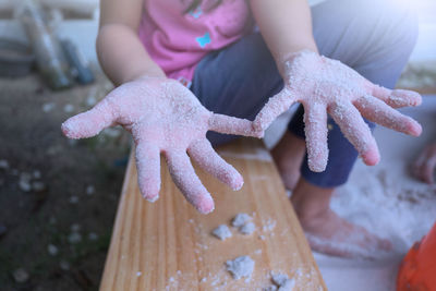 Low section of girl showing messy hands while sitting on seat