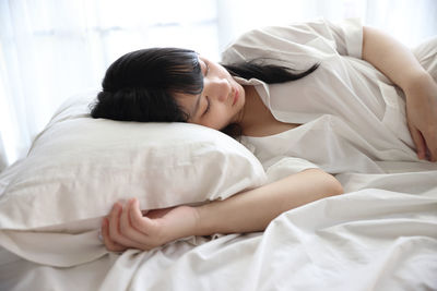 Young woman sleeping on bed at home