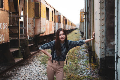 Young woman looking away while standing by train