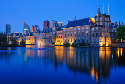 Reflection of buildings in city at dusk