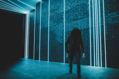 Woman standing against illuminated lights at night