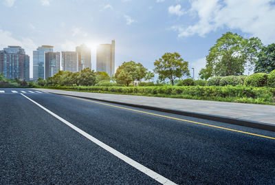 Surface level of road by city against sky