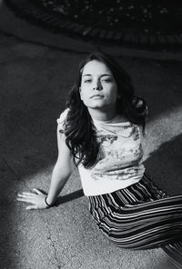 High angle portrait of woman sitting outdoors at night