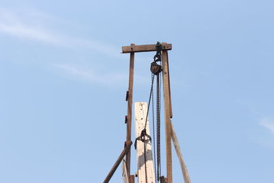 Low angle view of crane against blue sky