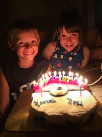 Portrait of happy children with birthday cake at home