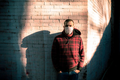 Young man standing against wall