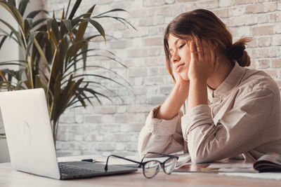 Teenage girl using laptop at table