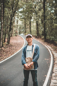 Portrait of young man wearing sunglasses against trees