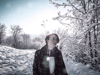 Man standing in snow against trees during winter