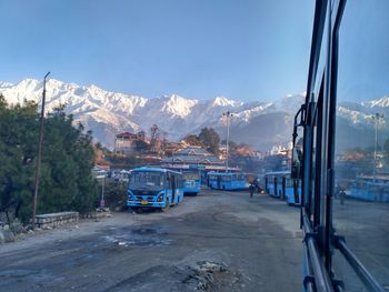 Cars on snowcapped mountains against sky