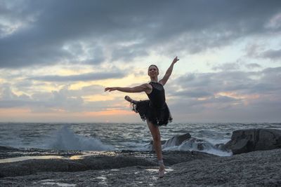 Silhouette of woman jumping on beach