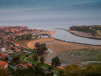 High angle view of buildings by sea against sky