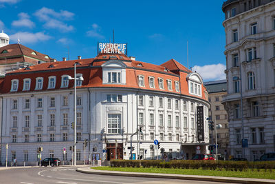 Buildings by road against sky in city