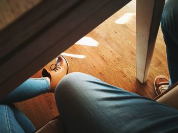 Low section of woman sitting on hardwood floor