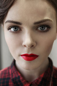 Close-up portrait of young woman with red lipstick