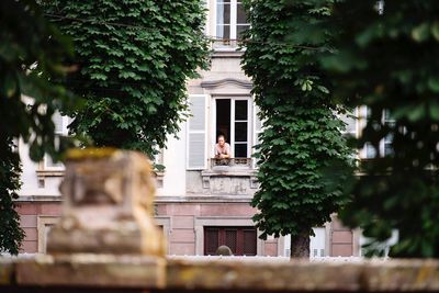 Statue by tree against building