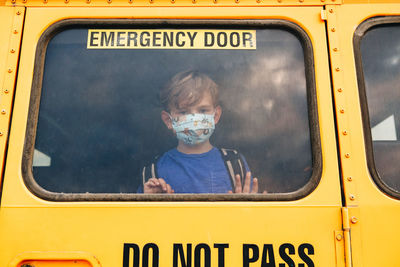 Full length portrait of boy against car