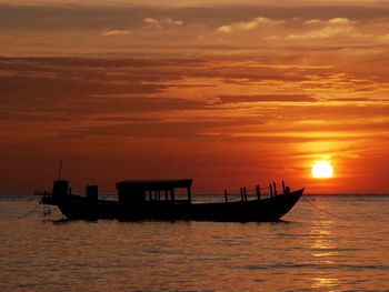 Silhouette boat in sea against sky during sunset