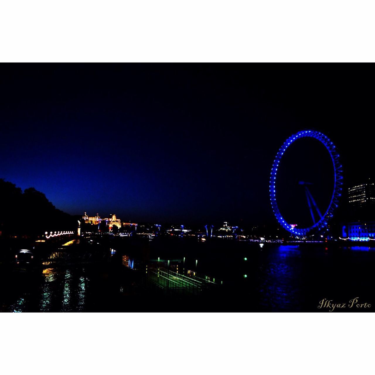 illuminated, night, transfer print, architecture, building exterior, built structure, city, auto post production filter, cityscape, water, copy space, river, clear sky, sky, blue, ferris wheel, travel destinations, tower, connection, waterfront