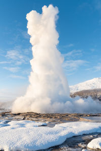 Scenic view of geyser  against sky