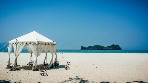 Scenic view of beach against clear blue sky