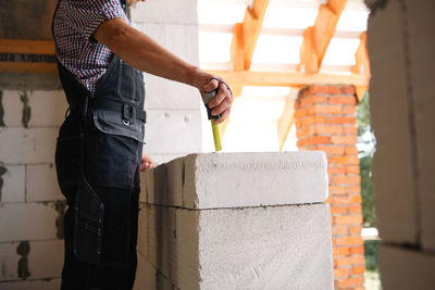 Low section of man standing against wall