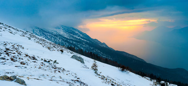 Scenic view of snowcapped mountains against sky during sunset