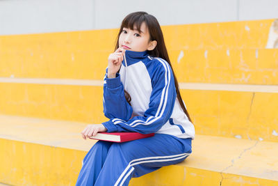 Portrait of young woman sitting on staircase