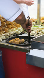 Midsection of man preparing food at market stall