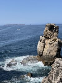 Rock formation on sea against sky