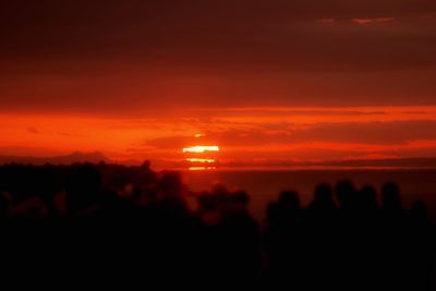 Scenic view of silhouette sea against orange sky