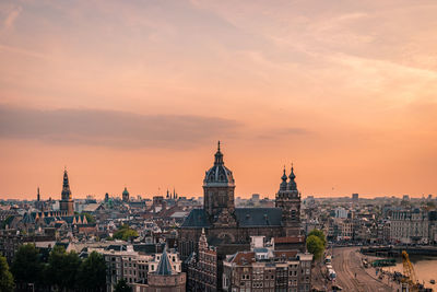 View of buildings in city against sky during sunset amsterdam 