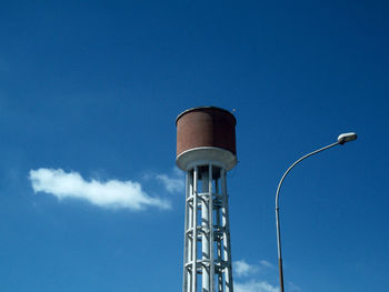 Low angle view of water tower against blue sky