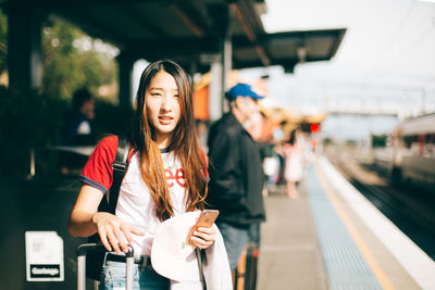 Young woman standing on railroad station platform