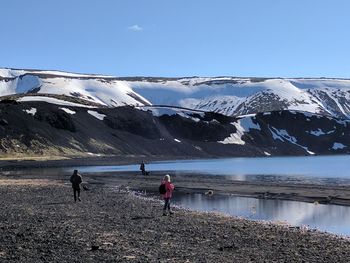 People on snowcapped mountain against sky