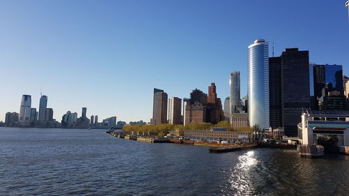 River amidst buildings in city against clear sky