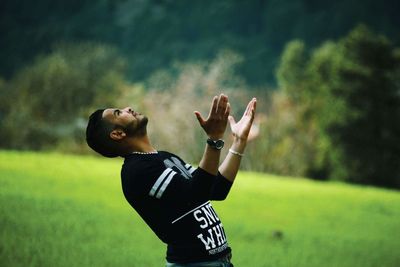 Man looking up on grassy field