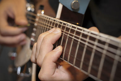 Midsection of person playing guitar